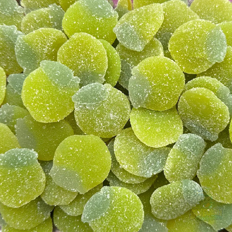 Close-up of green gummy candies with a textured surface. Sugared Coated Sweet Apples.